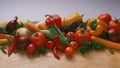 Vegetables - on a light background, on a wooden the table: tomatoes, cherry tomatoes on a branch, carrots, red onion